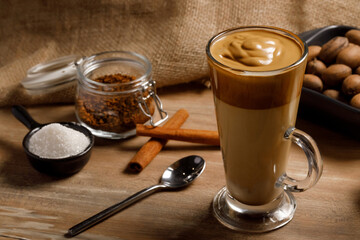 Dalgona coffee - the Korean coffee drink on wooden background. Instant coffee or espresso powder whipped with sugar and hot water. Iced whipped dalgona coffee concept.