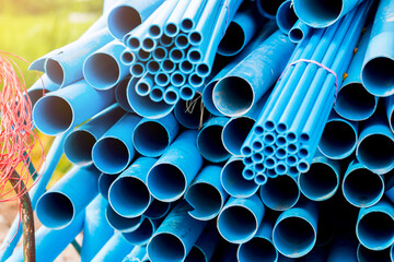 Selective to blue plastic pipe background. PVC pipes stacked in warehouse of construction site.