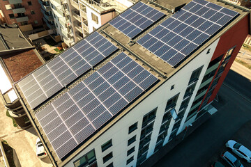 Aerial view of solar photovoltaic panels on a roof top of residential building block for producing...