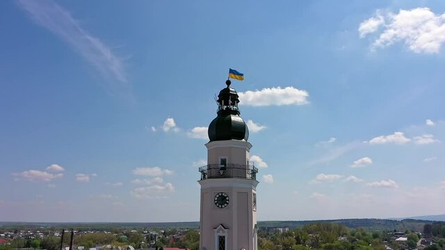 City council with Ukrainian blue and yellow flag rises above the old European city Drohobych. Beautiful historical landmark. Aerial drone view of cityscape from high