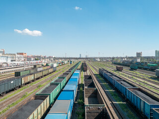 Railway station, railway cars, coal gondola car, blue sky.