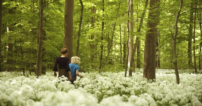 Siblings Carefully Watching Their Step While Surrounded by White Flowers