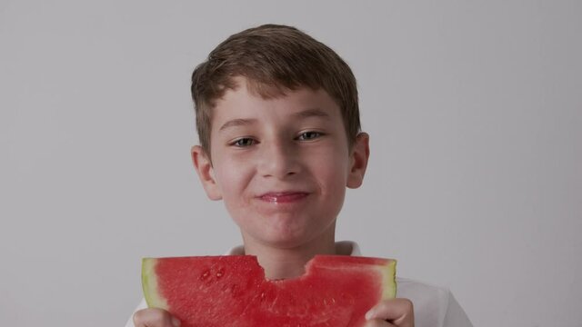girl eating watermelon smiling on a white background
