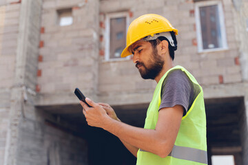 Real construction worker using mobile telephone