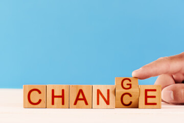 concept chance to change. male hand flips over a wooden block and changes the inscription from the word chance to words change