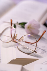 Óculos em cima de um livro aberto