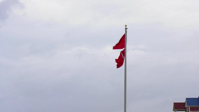 Double red flags indicating dangerous ocean surf, swimming banned