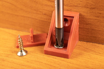 Plastic brackets for connecting chipboard. Small carpentry work in the workshop.