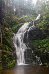 Waterfall flowing in the mountains. Watercourse flowing through a mountainous area.