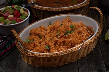 Mexican rice served in ceramic dish on wooden table
