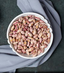 White beans in a white bowl on a wooden board