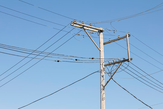Utility Pole with Many Lines against a Blue Sky