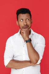 Serious african american young man thinking over red background.