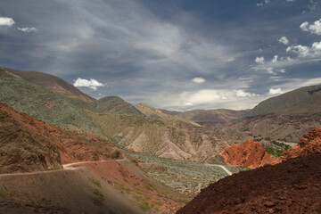 Desert landscape. Geology. Colorful rocky formations. Dirt road across the mountains. 