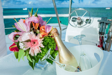 Champagne sparkling wine bottle and glasses at outdoors wedding catering event pouring into the...
