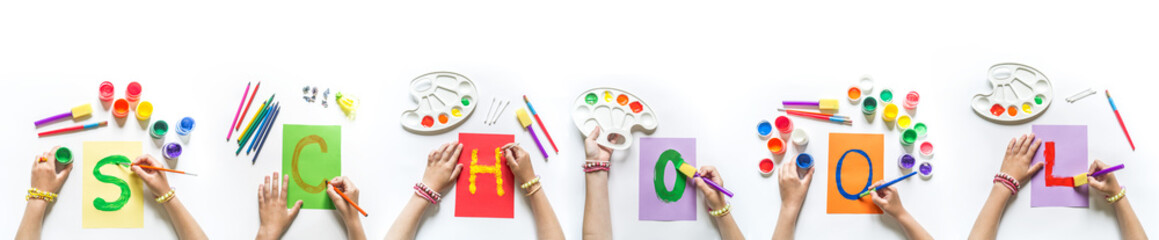 Obraz premium Children's hands write the word School
