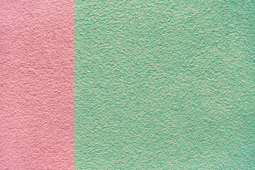 Green and pink colors concrete cement stone wall textured background for design and decoration. Two tone abstract background fashionable glamorous divided into two parts.