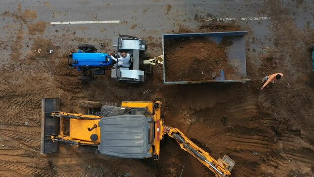 Jcb digger filling soil in trolley