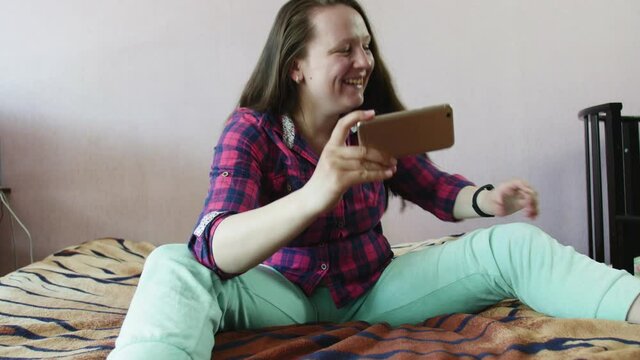 Young smiling woman blogger recording video on mobile phone.