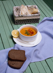 Lentil soup served with lemon and bread slices
