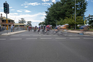 Obraz premium A criterium, or crit bike race consisting of several laps around a closed circuit. Bike riders racing, motion blur