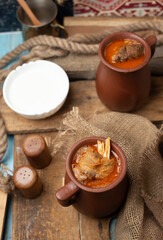 Obraz na płótnie Canvas Traditional caucasian piti soup in pots served with yogurt
