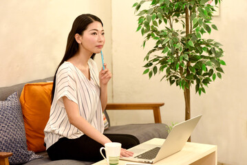ペンを持ちながら考える女性