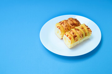 Loaves of cheese read in a plate on blue background 