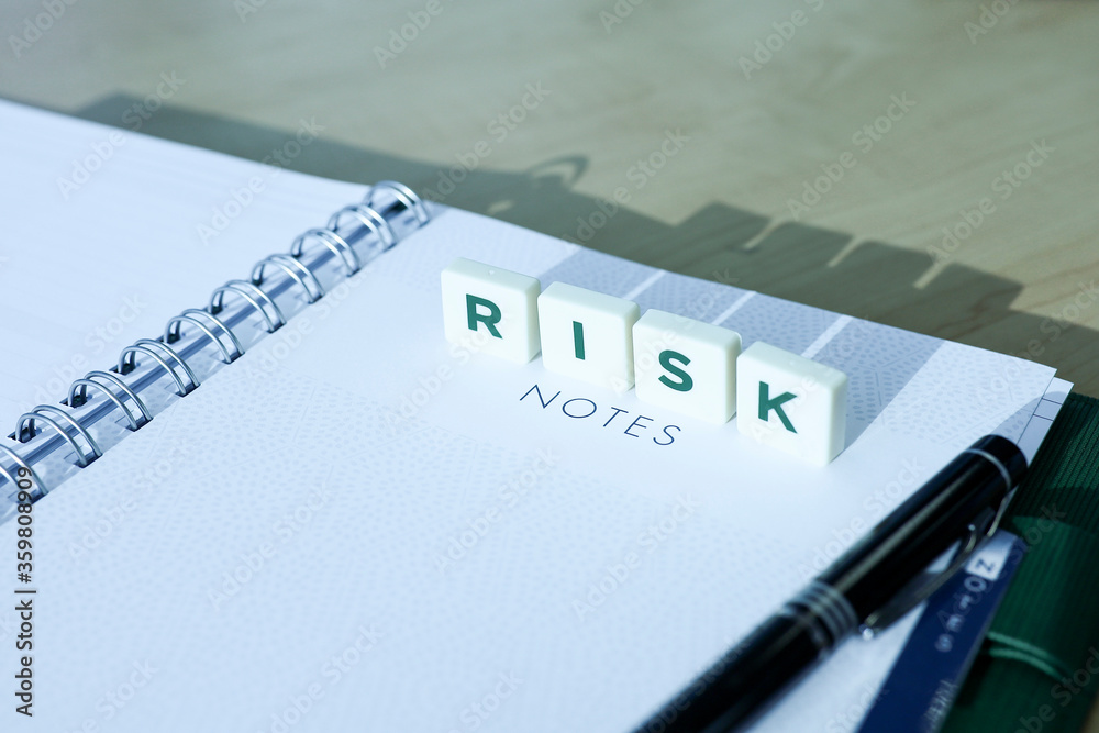 Wall mural block letters on notebook cast a shadow on wooden table