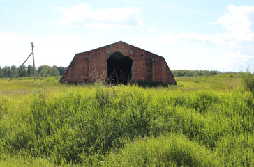 Obraz premium destroyed abandoned building ruins with an opening for the farm hangar