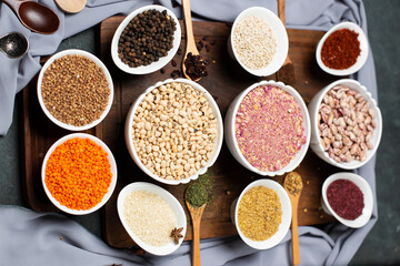 Fototapeta na wymiar Sumakh, rice, beans, buckwheat and red lentils in a white bowl on a wooden board