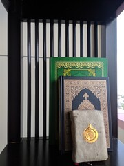 Al quran on the wooden shelf. Arabic word translation: The Holy Al Quran (holy book of muslims) - public item of all muslims.