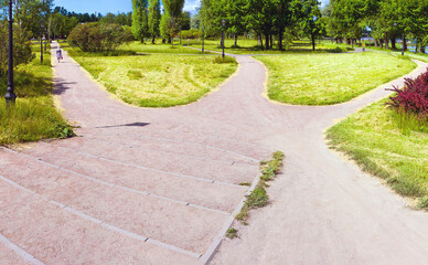 The path in the park is divided into three alleys going in different directions. Conceptual summer landscape