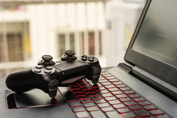 a video game controller on keyboard laptop. © Jaturapat