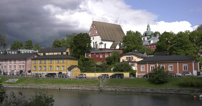 4K video of Porvoo medieval vintage cathedral, Porvoo Cathedral, yachts and boats in Porvoonjoki River near town center on sunny summer day in Finland, northern Europe