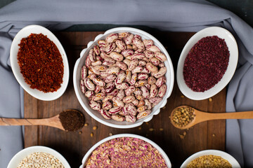Sumakh and white beans in a white bowl on a wooden board
