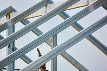 the worker welding metal on roof structure