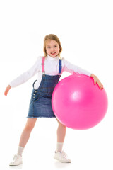 Little girl plays with a big ball for fitness