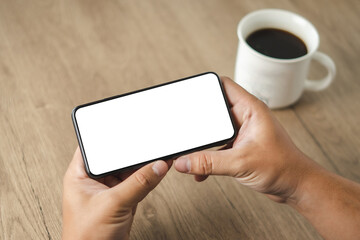 Top view Mockup image hand using a smartphone man Holding Cell Phone With Blank Screen
