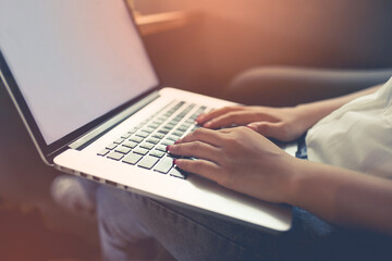 Closeup of a woman hands typing a laptop on the table .business concept