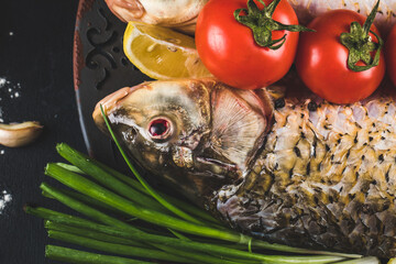 Raw fish with greenery, tomatoes and lemon