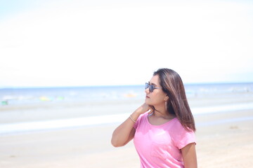 Fototapeta na wymiar Asian women wearing pink shirts are stand with joy and freshness. On active, air, beach, beautiful, beauty, bikini, blue, body, carefree, concept, enjoy on summer holiday, Summer concept. Happy summer