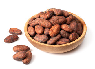 unpeeled cocoa beans in the wooden bowl, isolated on white background