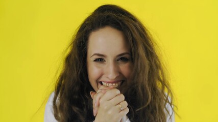 Young beautiful Caucasian woman is very happy on yellow background. Woman heard the good news