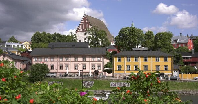 4K video of Porvoo vintage red wooden buildings, Porvoo Cathedral, yachts and boats in Porvoonjoki River near town center on sunny summer day in Finland, northern Europe