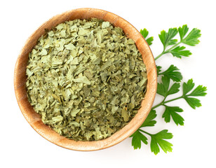 dried parsley flakes in the wooden bowl, isolated on white background, rop view