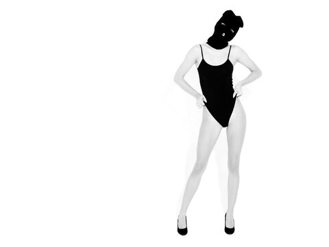 Beautiful sexy woman in black swimwear bathing suit. Model wearing bandit balaclava mask.Hot girl posing near white wall in studio.Seductive female in nice lingerie.Crime and violence