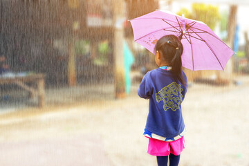 The girl with umbrella and looking at something at home in the rain.