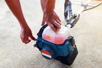 man is pressing Engine shock before start engine Of the mower