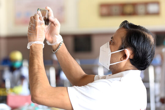 A young man at work during Covid-19 pandemic. young man in mask and gloves shooting during lock down in India wearing N95 mask. 
